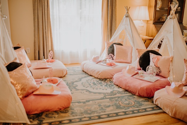 Styled white teepees with pink cushions, cowboy hats, and disco decor