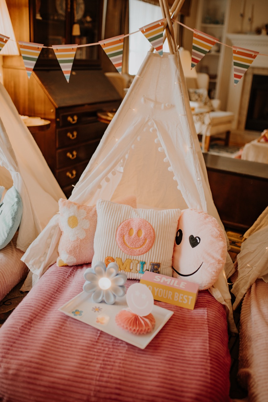 Flower Power themed teepee with rainbow bunting, smiley cushions, and flower tray lamp