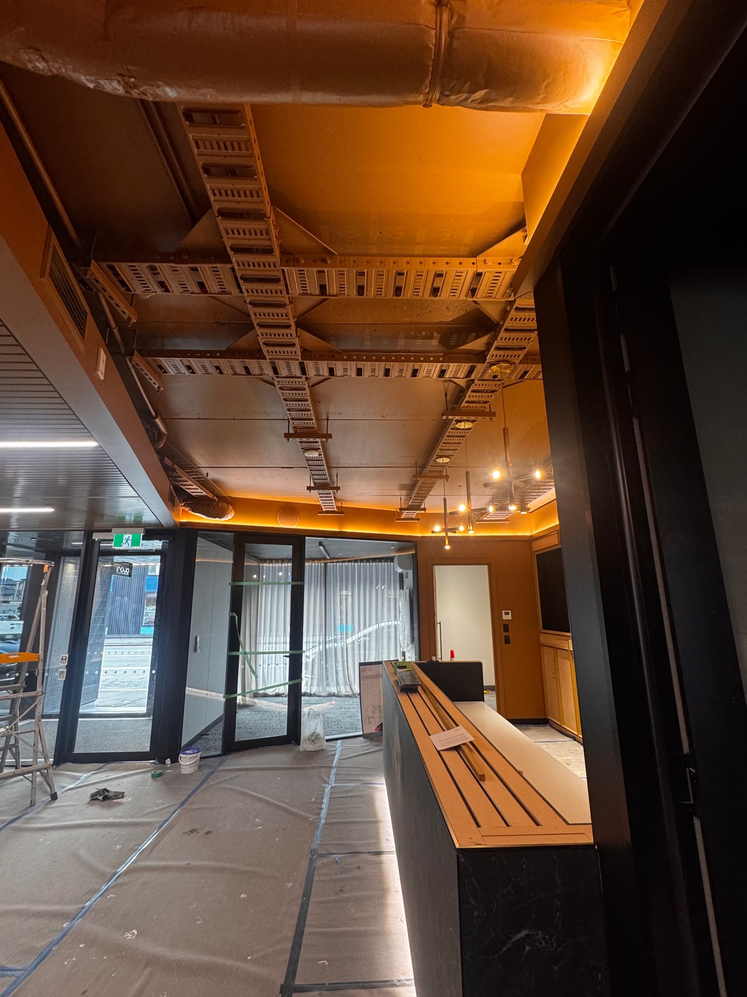 Commercial interior fitout in progress with careful floor protection, masking, and preparation underway