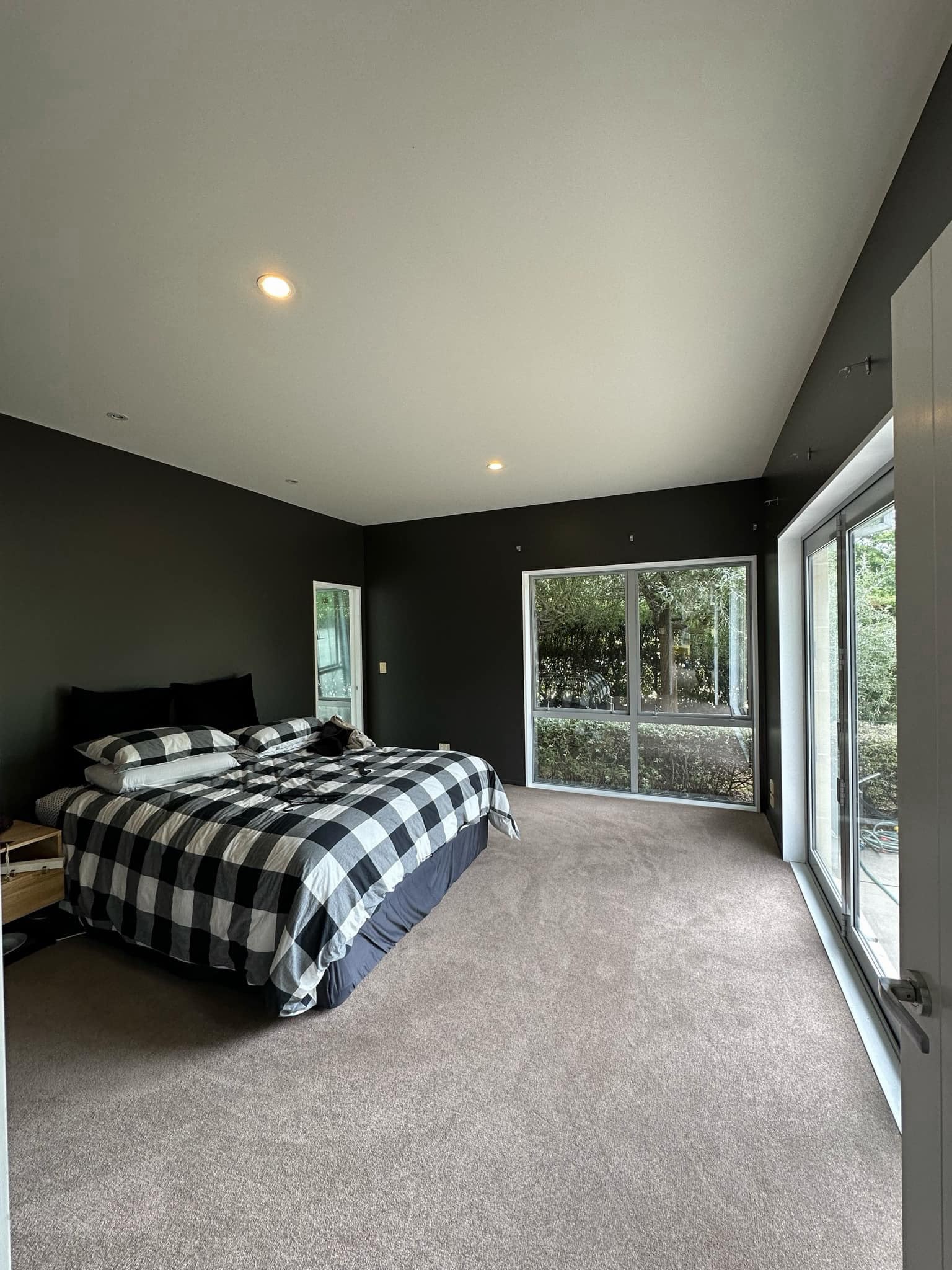 Finished Christchurch bedroom interior with deep charcoal walls and crisp white ceiling