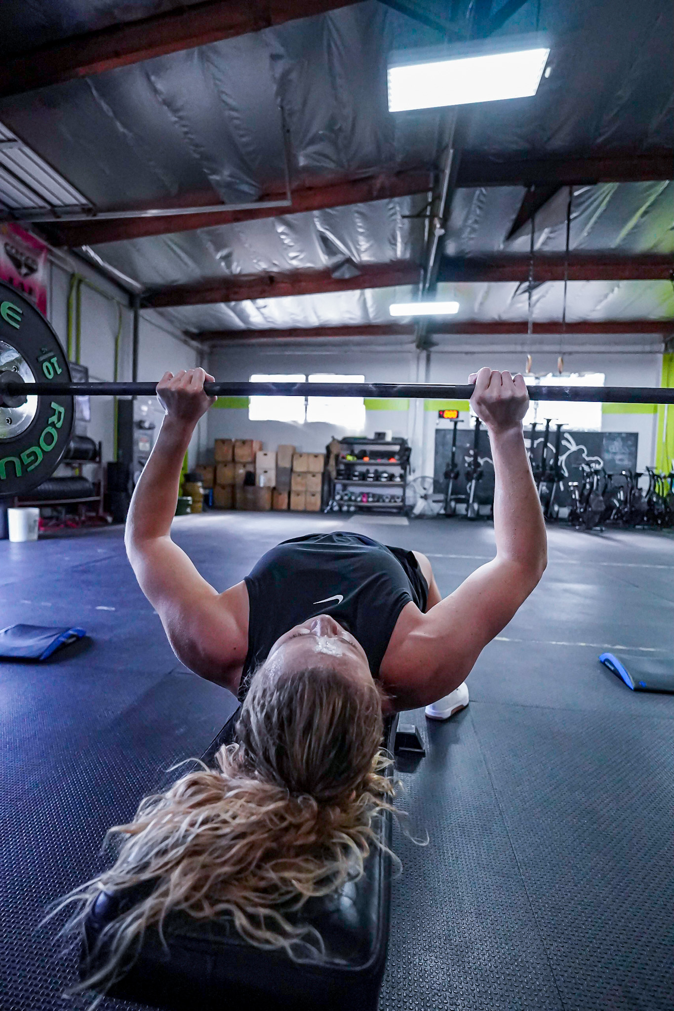 Lauran Orrin bench pressing barbell with focused strength