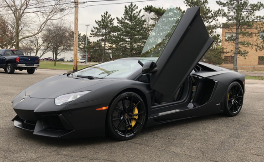 Black Lamborghini Aventador with scissor doors open, full matte PPF installed at Miami Glow Customs