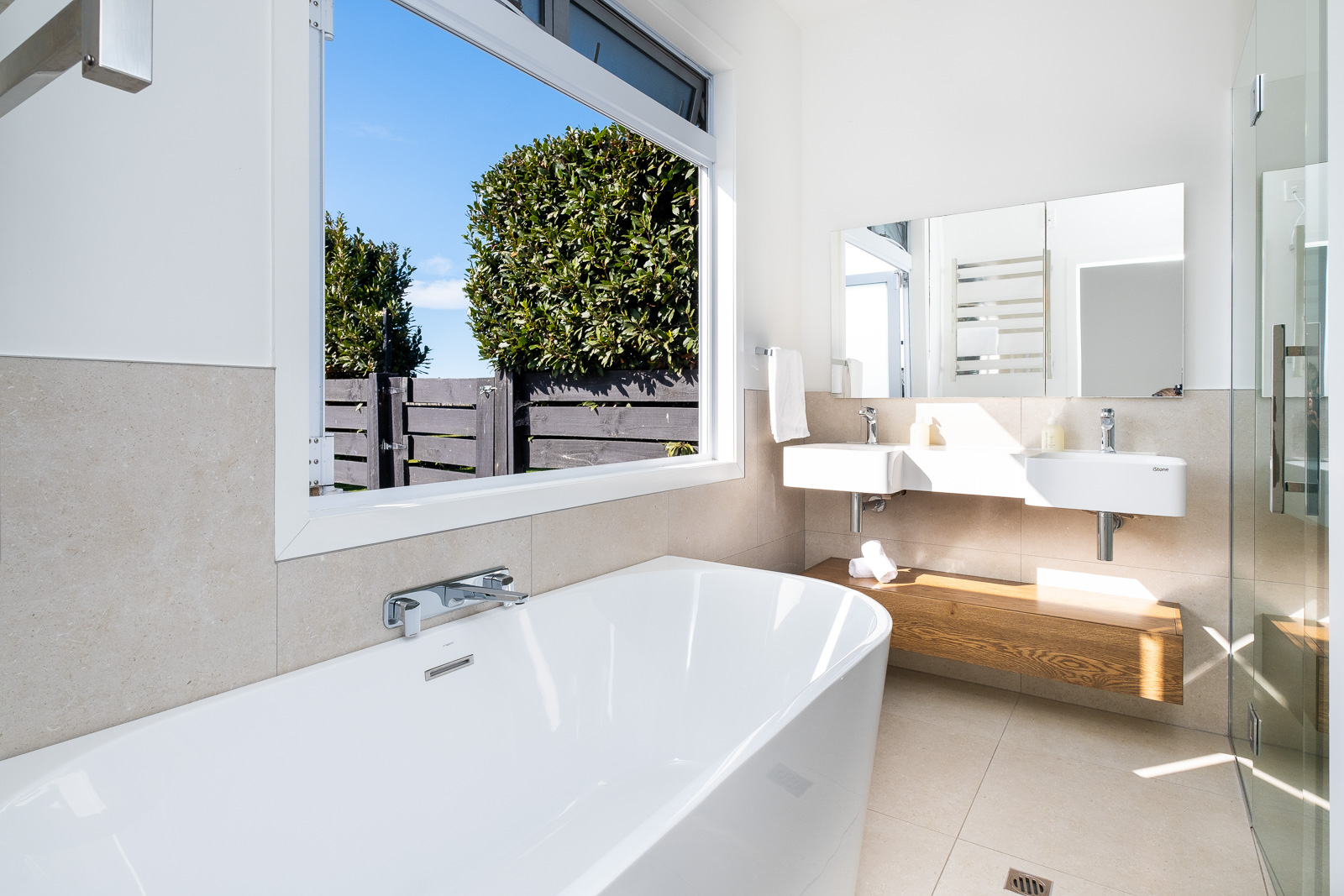Private ensuite bathroom with freestanding bath and garden view