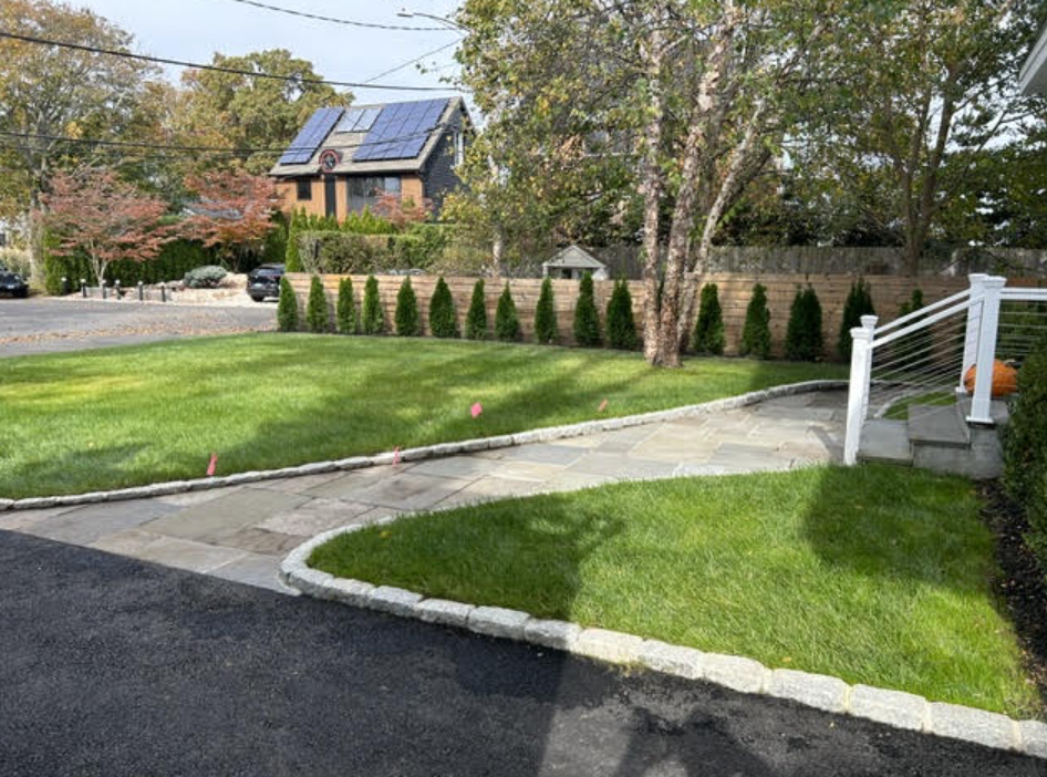 Rebuilt leveled flagstone walkway with crisp Belgian block curb edging leading to front porch