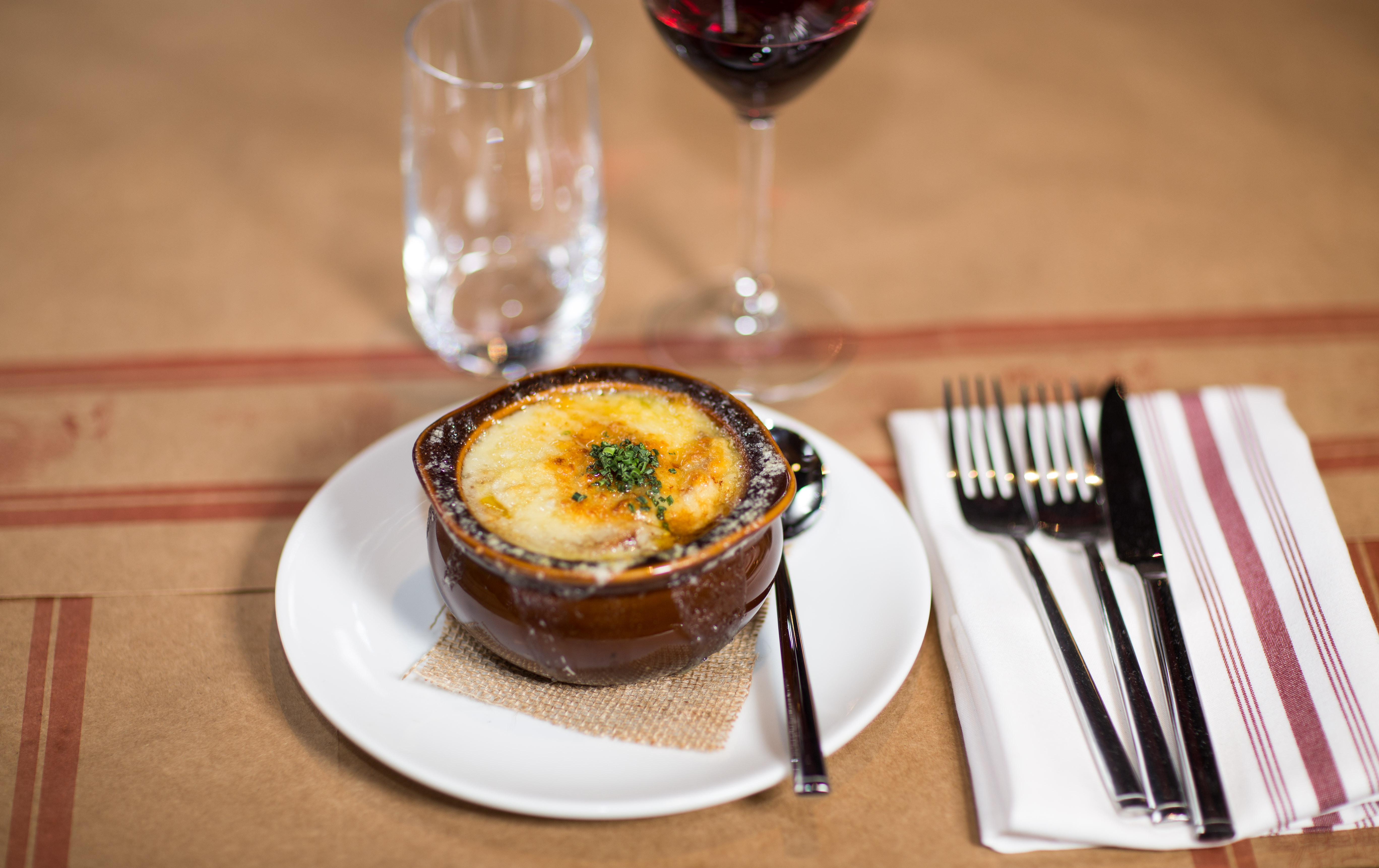 Traditional Soupe à l'Oignon Gratinée served with melted Emmental cheese and red wine at Et Voilà French Bistro San Diego