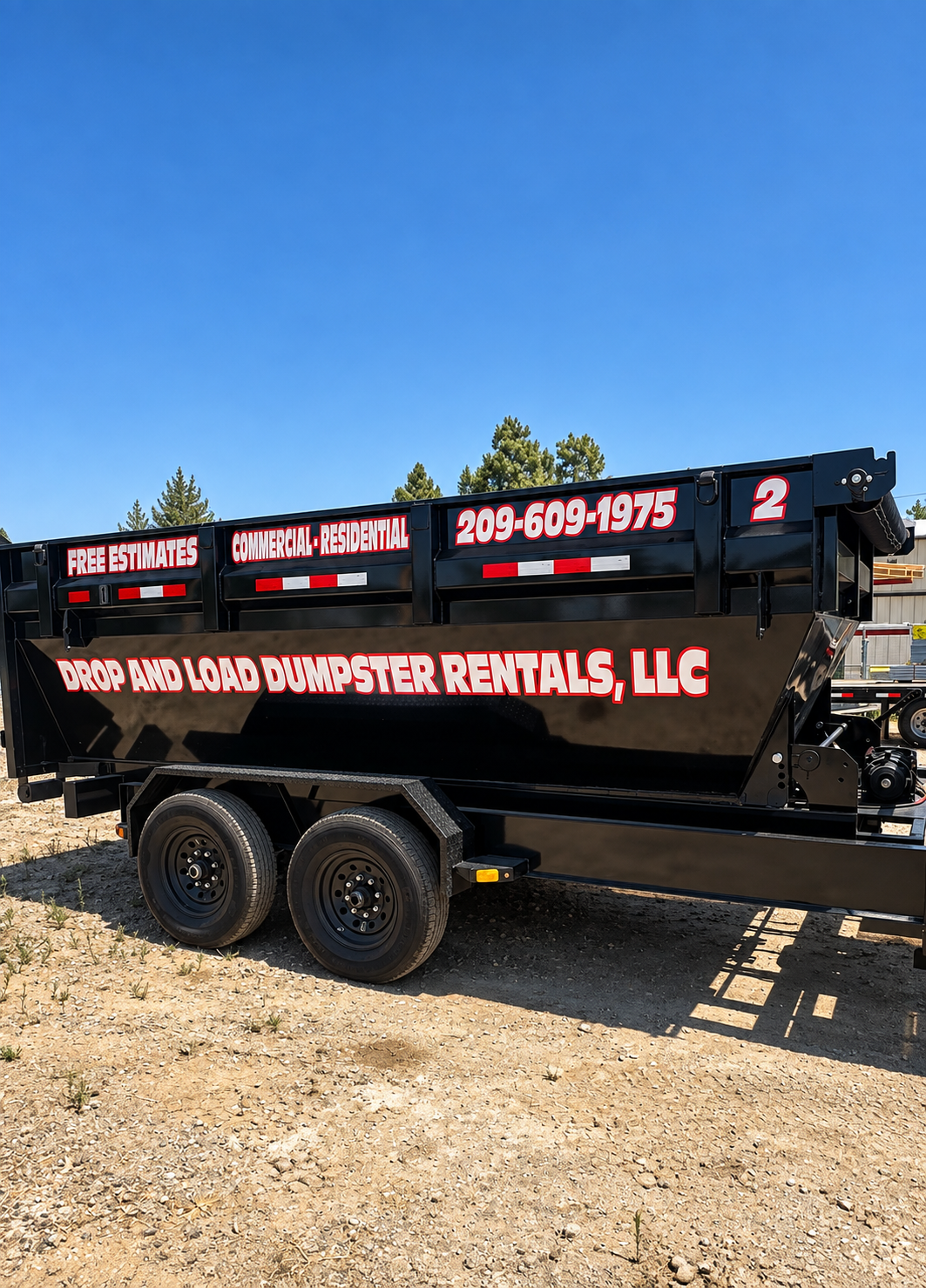 Drop And Load Dumpster Rentals branded black roll-off trailer dumpster with phone number and commercial residential lettering