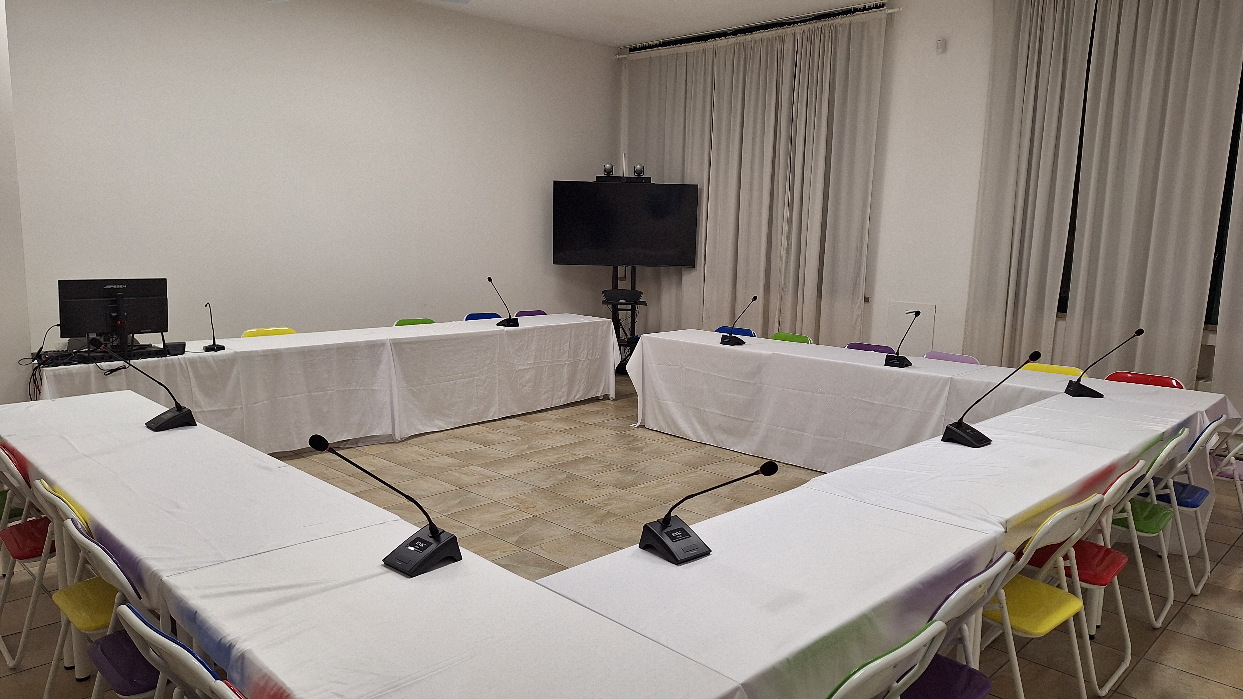Sala allestita per assemblee di condominio con postazioni e microfoni