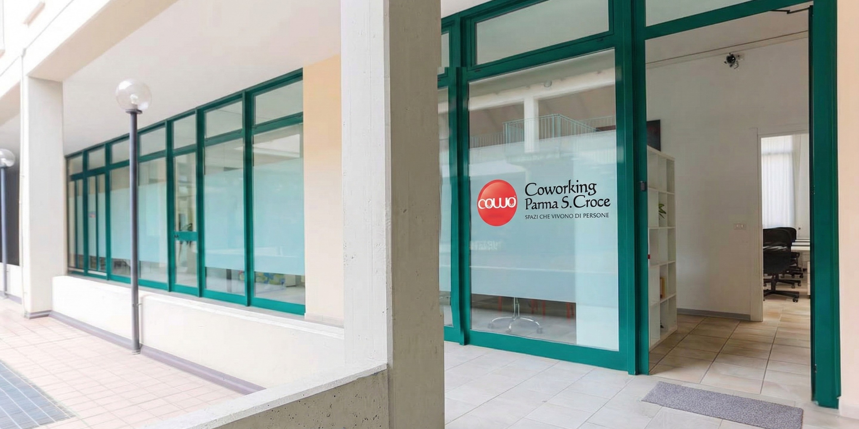 Vetrata e ingresso esterno del Coworking Parma Santa Croce con logo Cowo
