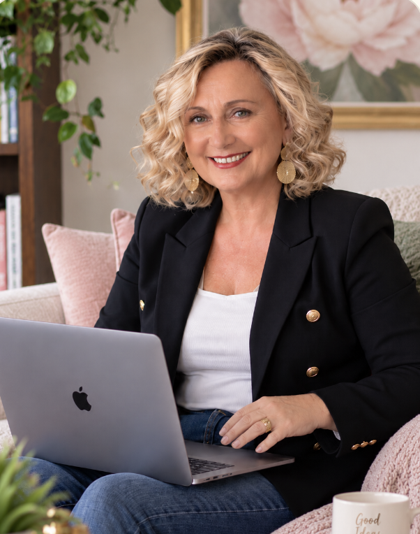 Angelique Pellegrino with laptop and soft pink flower decor