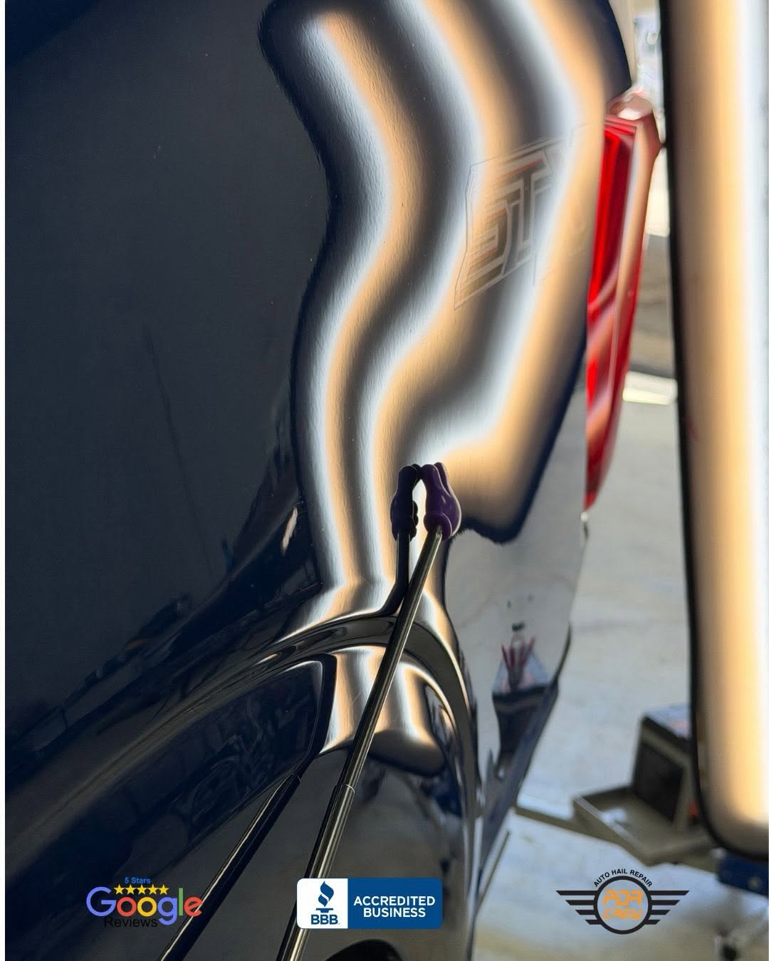 Paintless dent repair technician working on door panel reflection