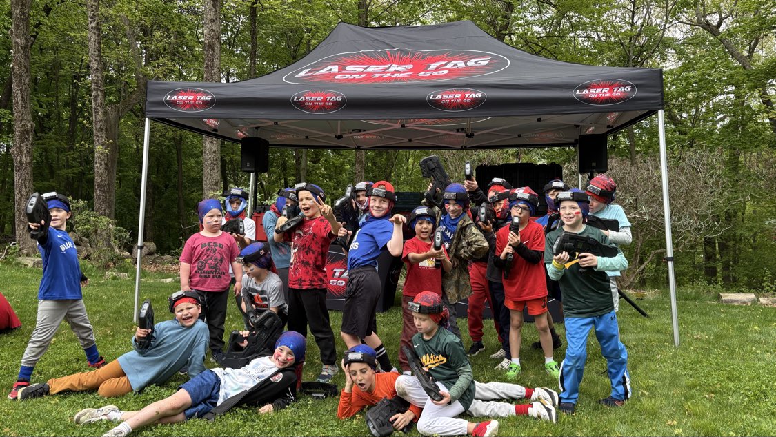 Laser Tag On The Go birthday party group under event tent holding blasters with Game Coaches