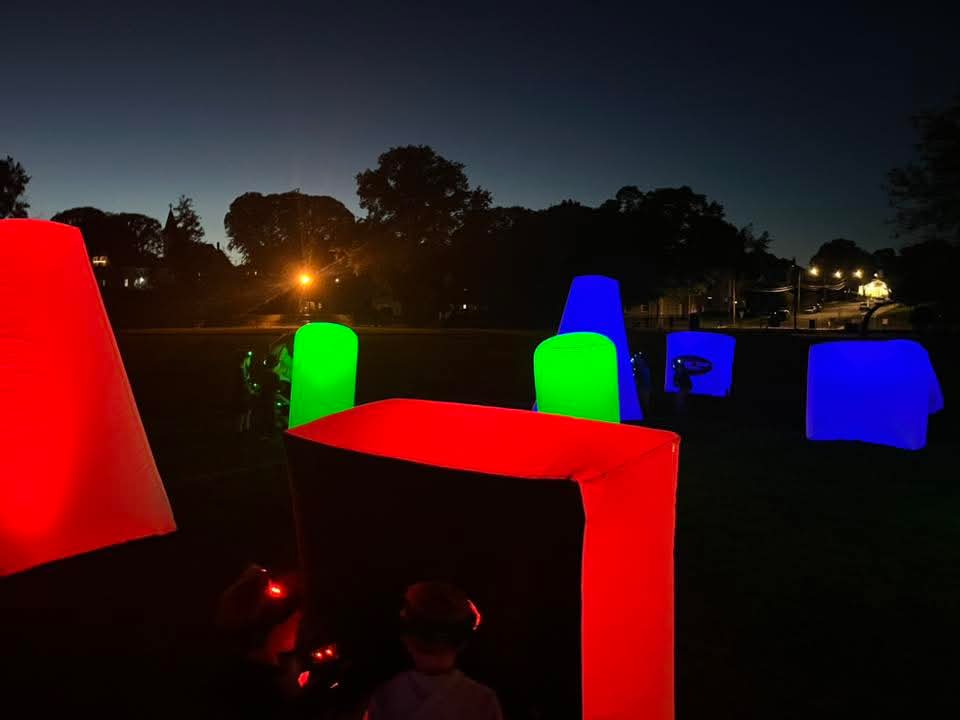 Color-Changing Glow Bunkers — illuminated red, green and blue inflatable bunkers on a nighttime field