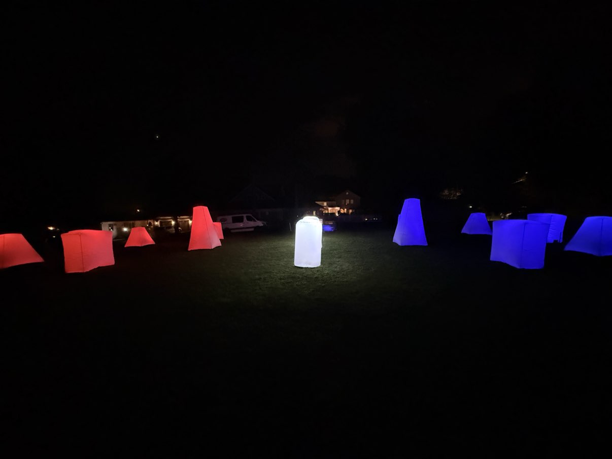 Glow Course at Night — illuminated red and blue inflatable bunkers