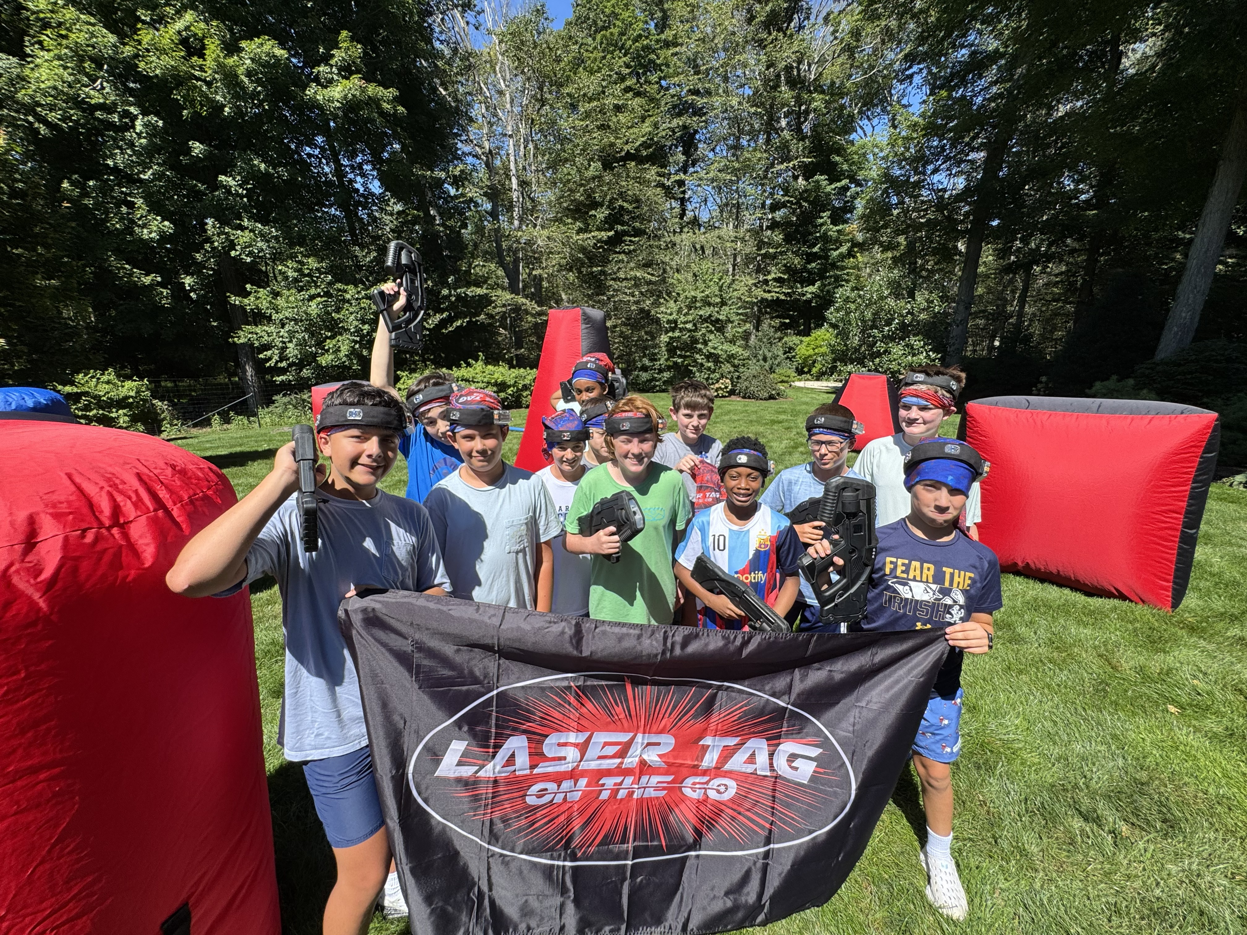 Kids at a Laser Tag On The Go birthday party with blasters, headbands and inflatable bunkers