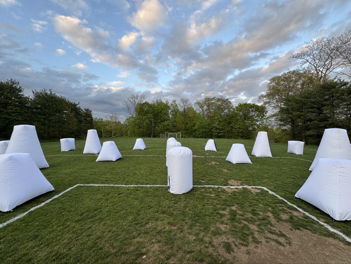 Laser Tag On The Go Glow Course outdoor grass field arena setup with white inflatable bunkers before event