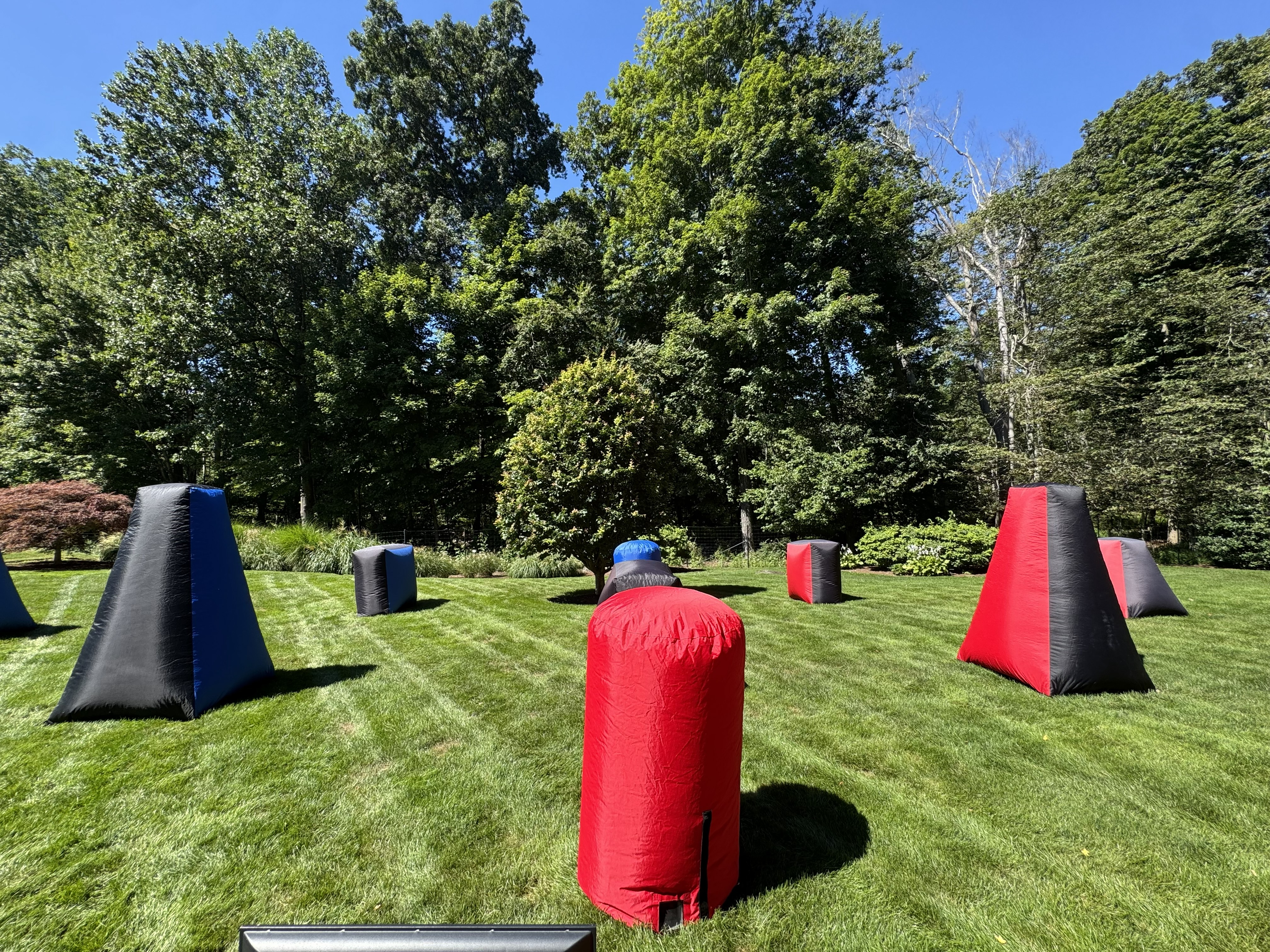Laser Tag On The Go backyard birthday field with red, blue and black inflatable bunkers