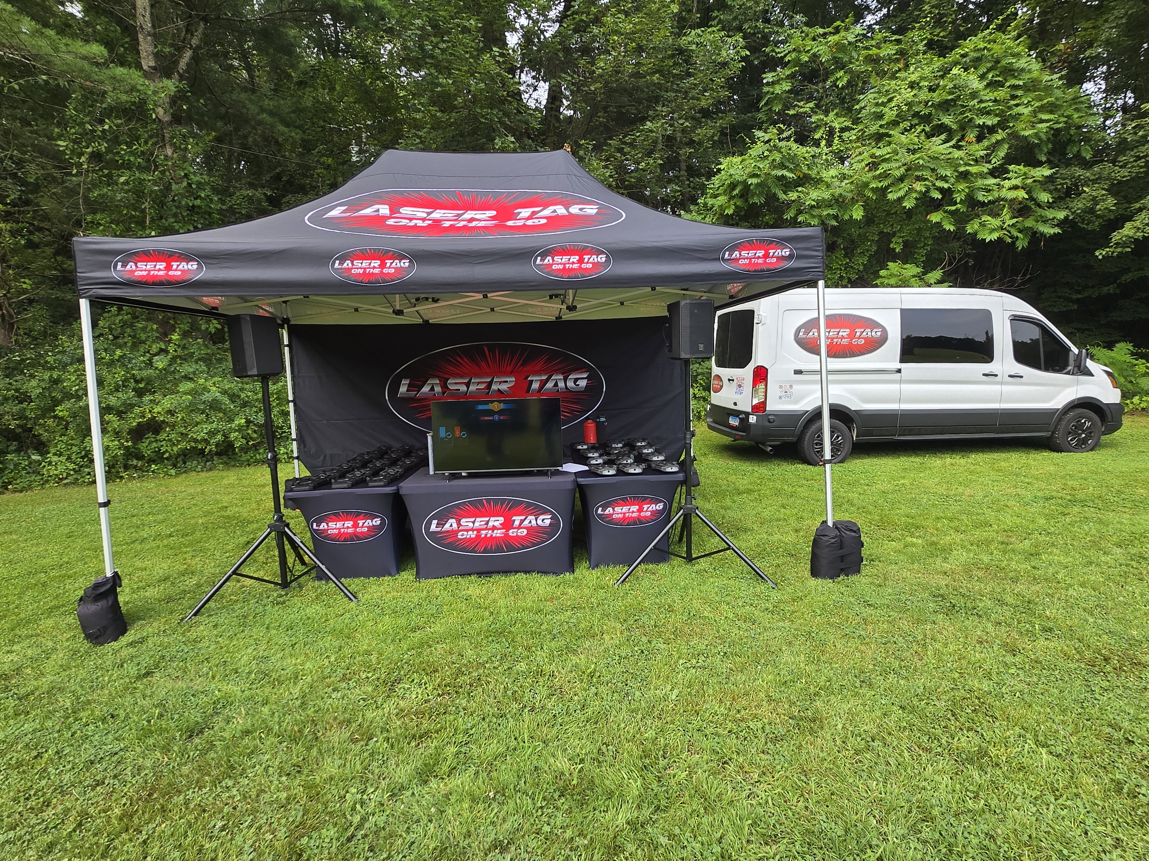 Laser Tag On The Go Setup — branded tent, display screen, sound speakers and mobile van setup