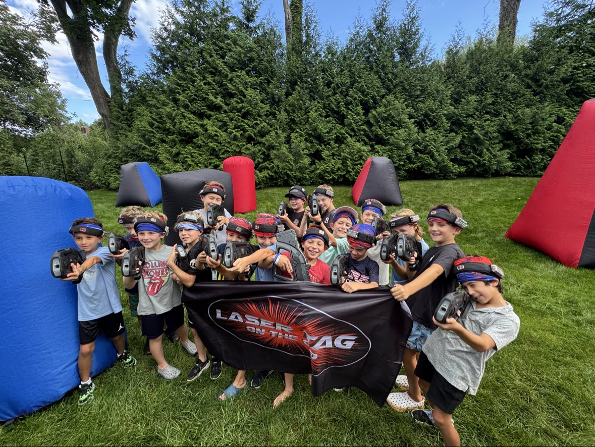 Laser Tag On The Go birthday party group photo with players holding blasters and event banner