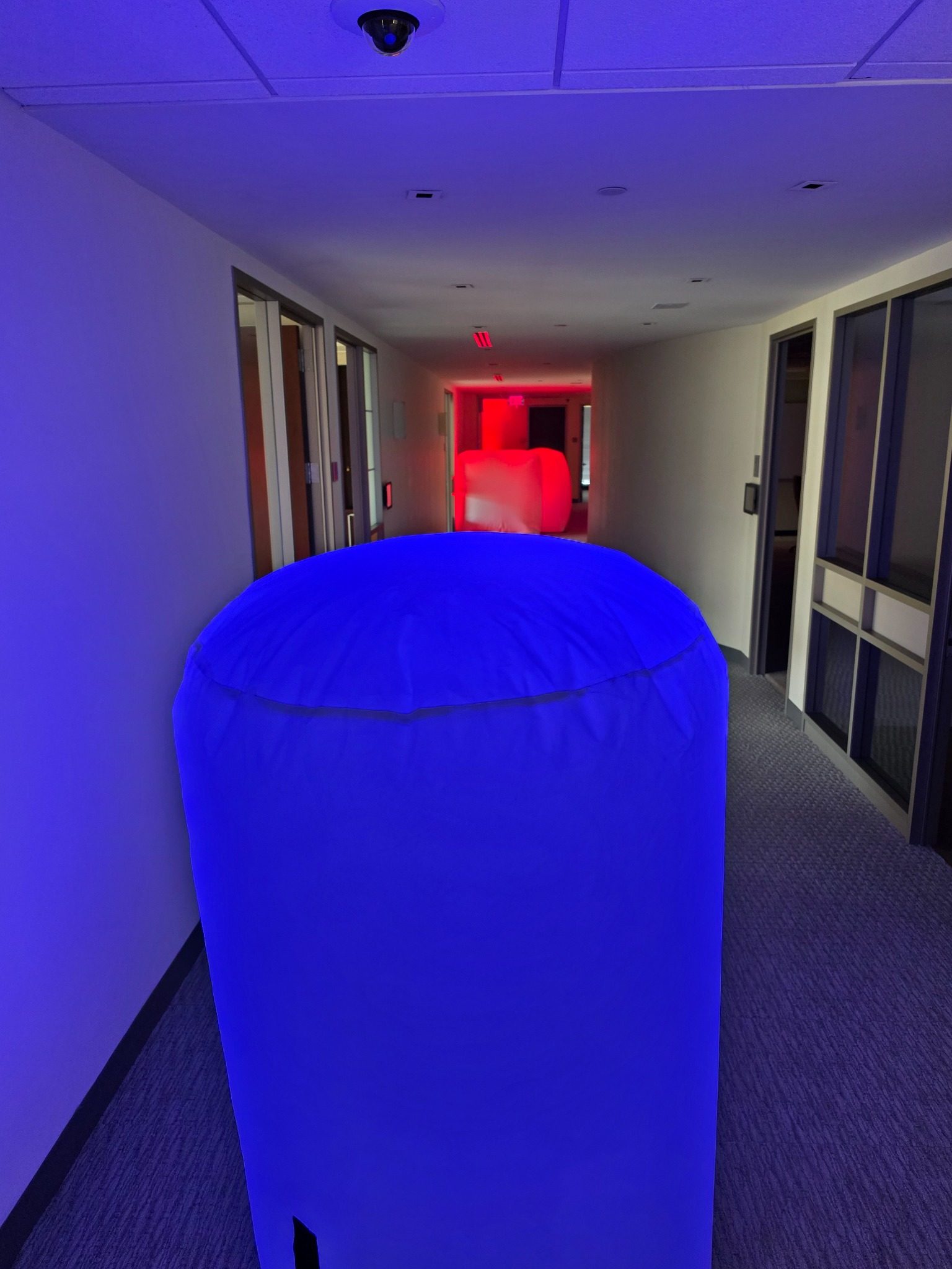 Indoor corporate office hallway laser tag course with illuminated glow bunkers