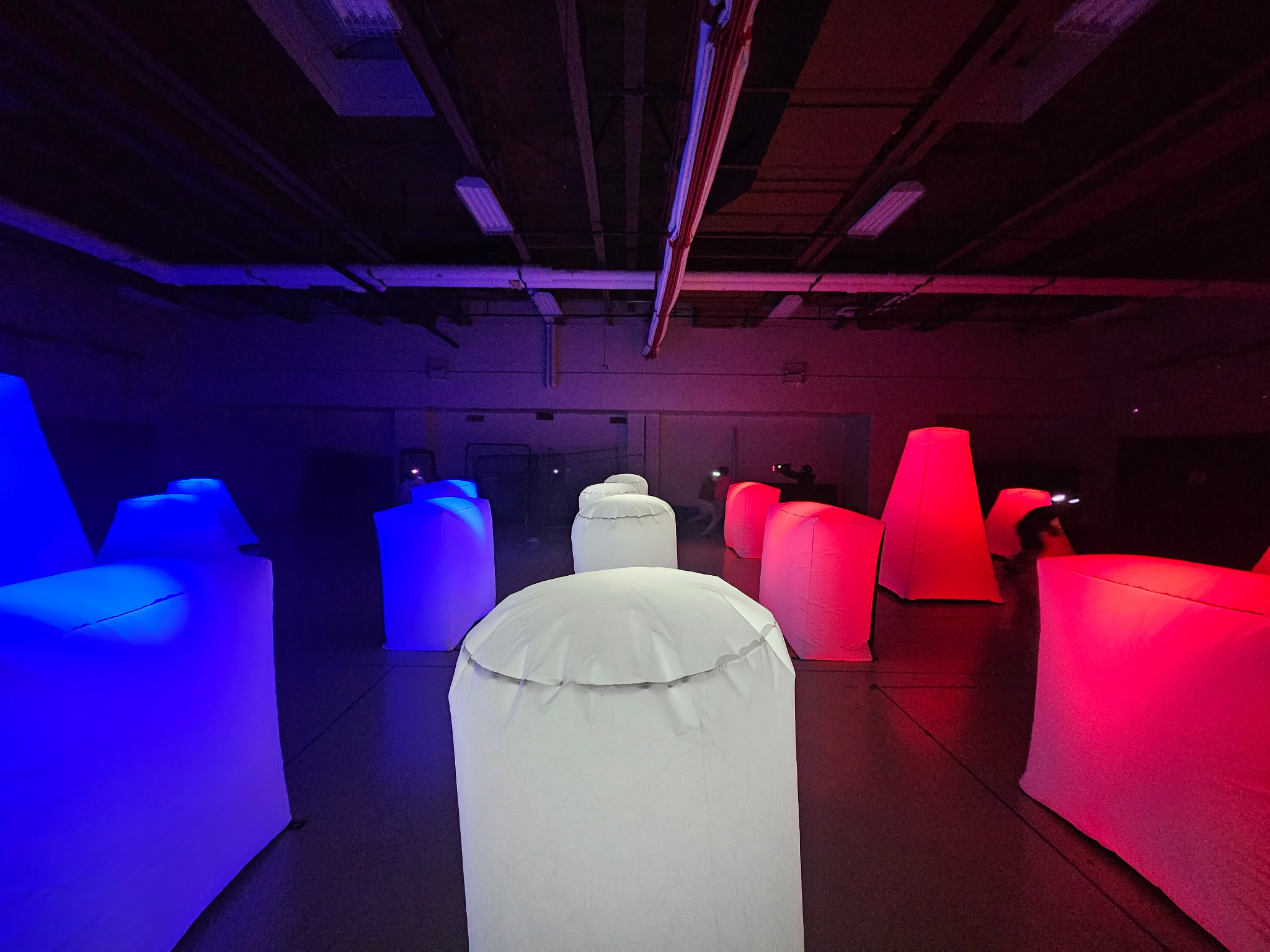 Indoor Glow Course — red, blue and white illuminated inflatable bunkers