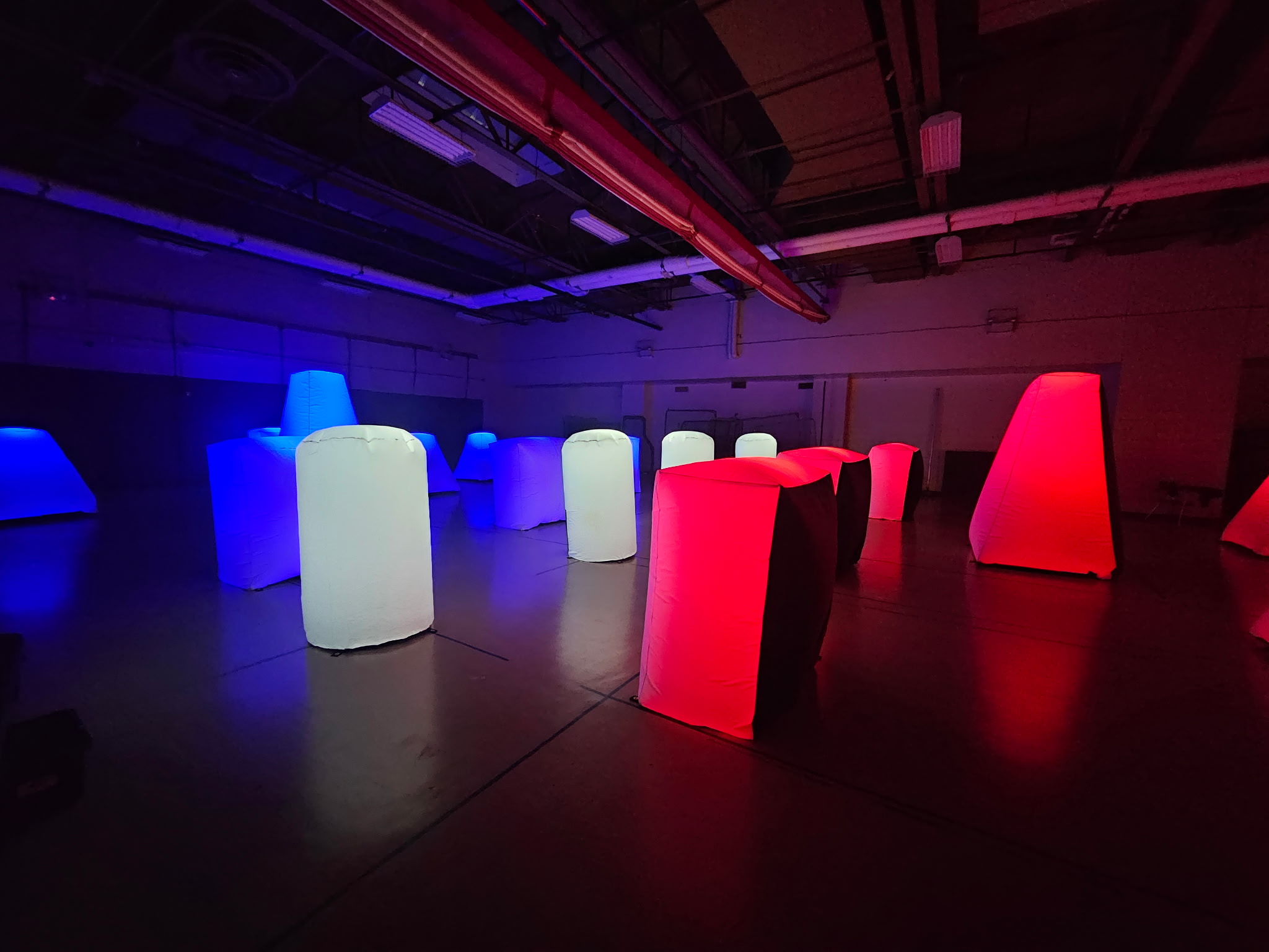 Indoor Glow Course — illuminated red, blue and white bunkers in a sports hall