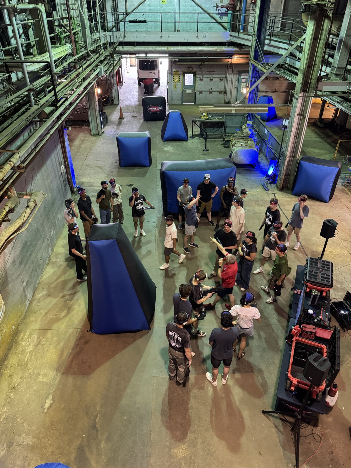 Corporate team building laser tag event in an indoor industrial facility arena with Game Coaches and players