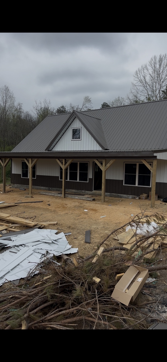 Joel Lindberg Residence — Finished two-tone metal siding with charcoal wainscot, white upper panels, and timber knee braces