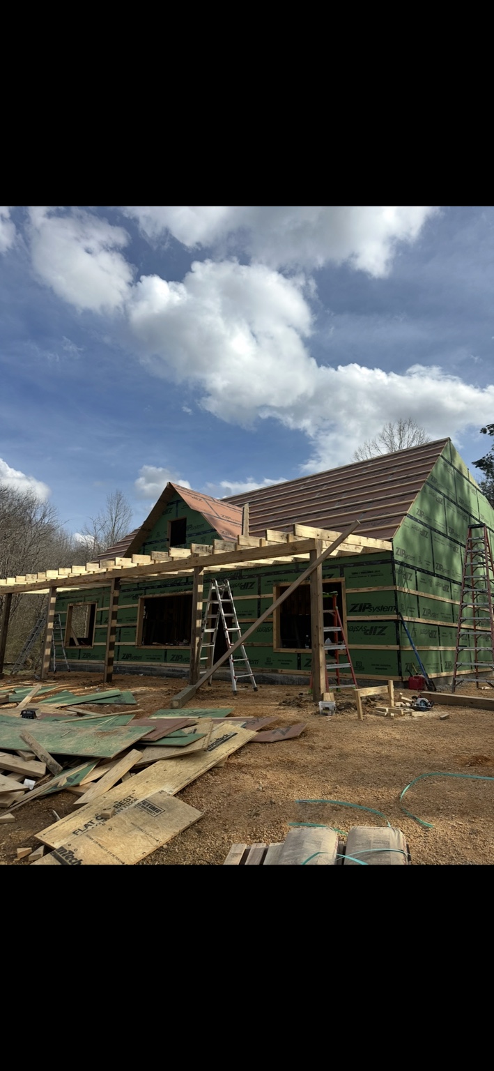 Joel Lindberg Residence — Front elevation with roof decking, gable dormer, and porch frame underway