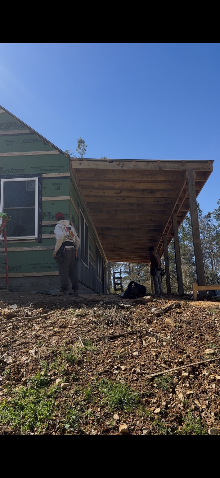 Joel Lindberg Residence — Deep covered timber porch profile and exposed rafter framing over natural grade