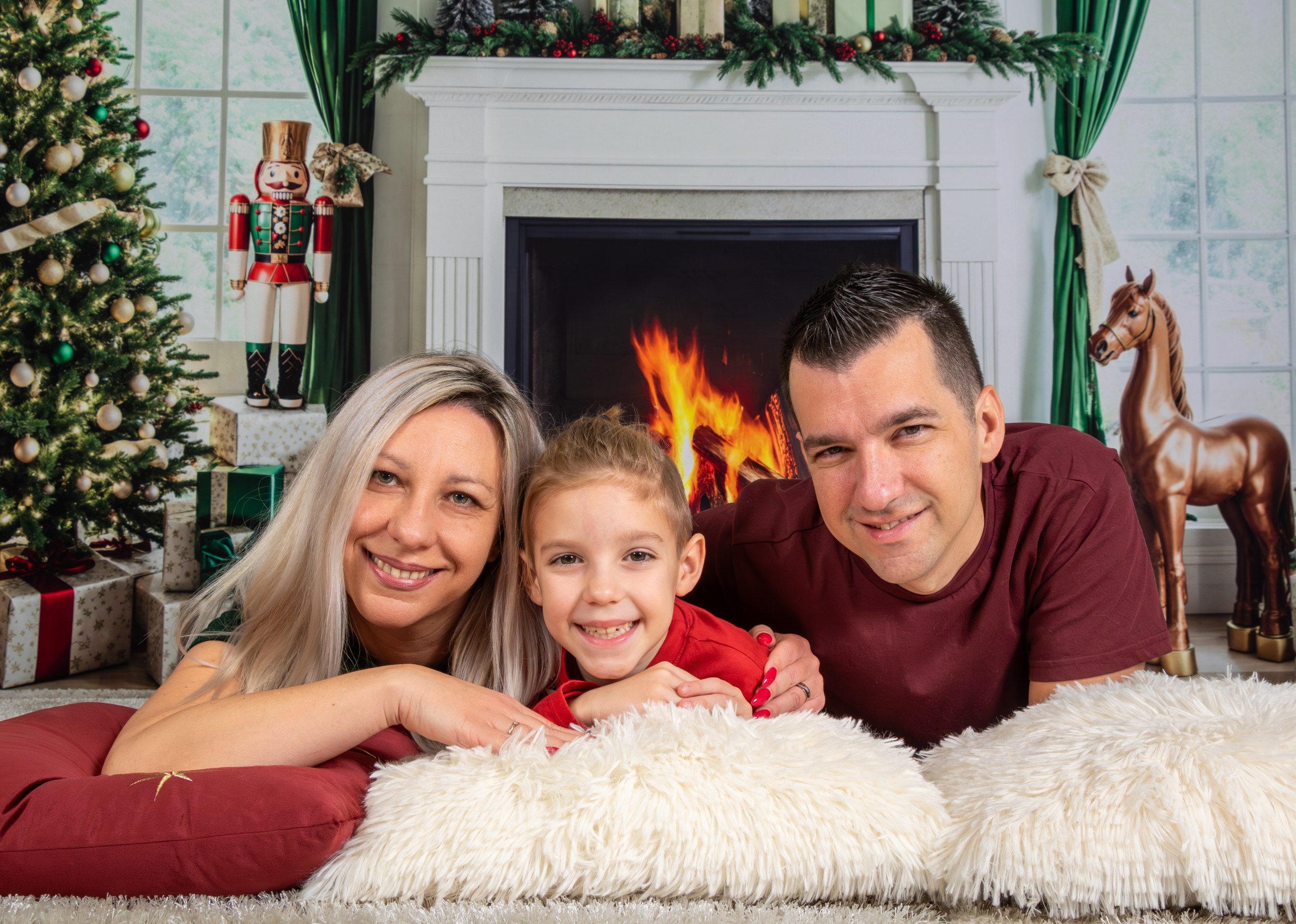 Družinsko božično fotografiranje pred kaminom v studiu Foto Tone