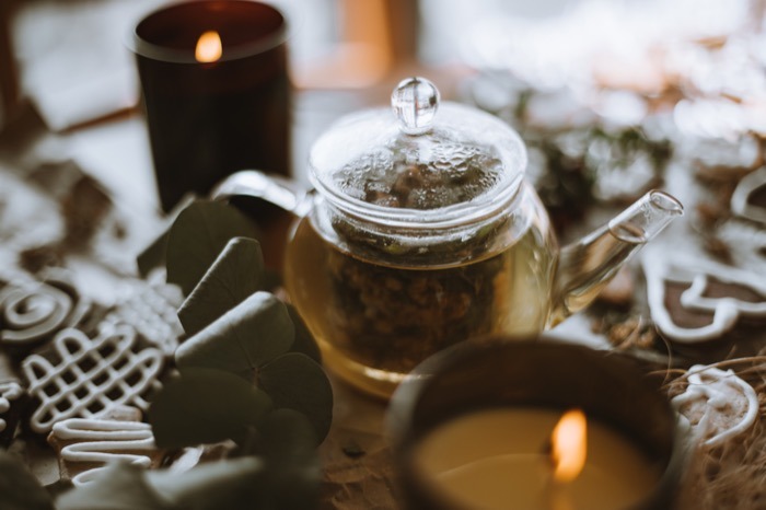 Tetera con velas y galletitas en un ambiente cálido de té de invierno