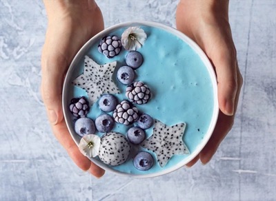 Smoothie bowl de blue matcha con yogur, arándanos, moras y estrellas de fruta