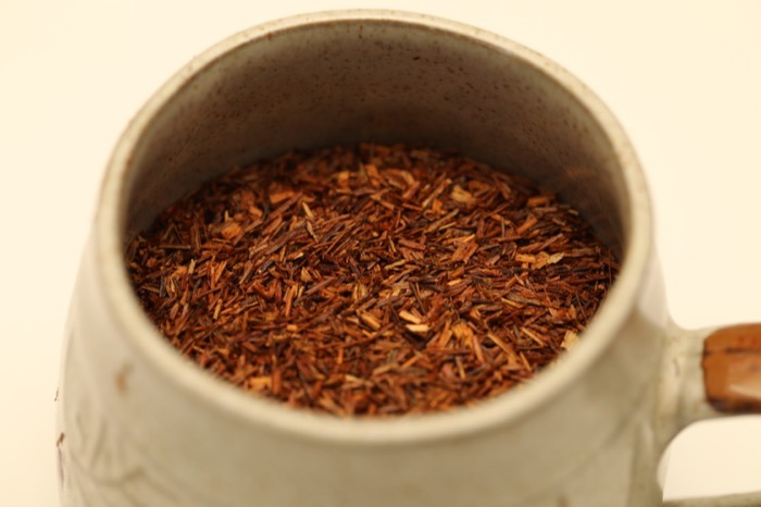 Hojas secas de rooibos en taza para infusión