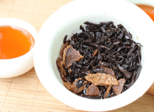Cuenco de té con infusión de Ju Pu Cha y hebras con cáscara