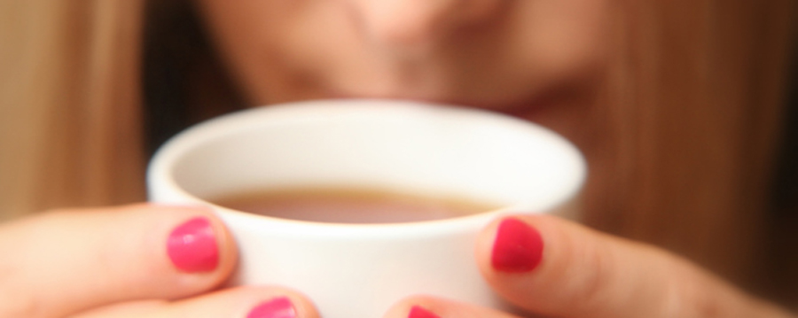 Persona oliendo y degustando una taza de té