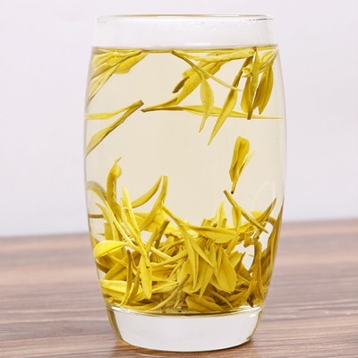 Infusión de té amarillo Jun Shan Yin Zhen en vaso de vidrio mostrando los brotes verticales