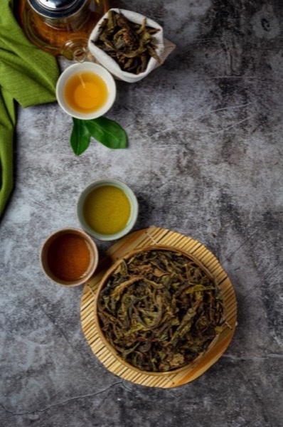 Cuencos de té y cuenco con hebras secas sobre esterilla
