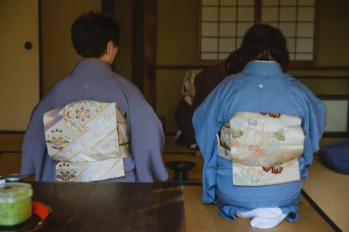 Mujeres vestidas con kimono tradicional sentadas sobre tatami en una sala de té japonesa