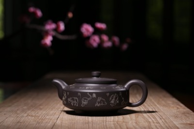 Tetera Yixing grabada con caracteres y figuras tradicionales chinas