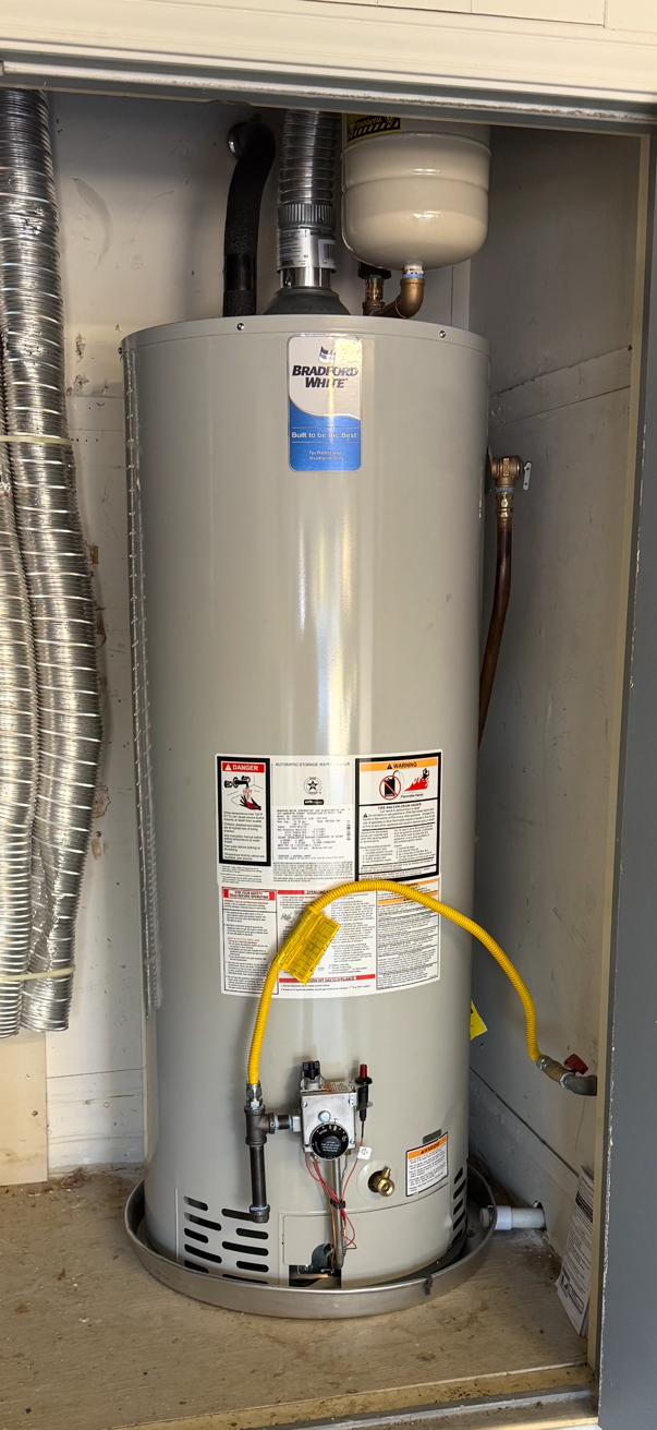 Gas water heater installed in closet with thermal expansion tank, sediment trap, and drain pan