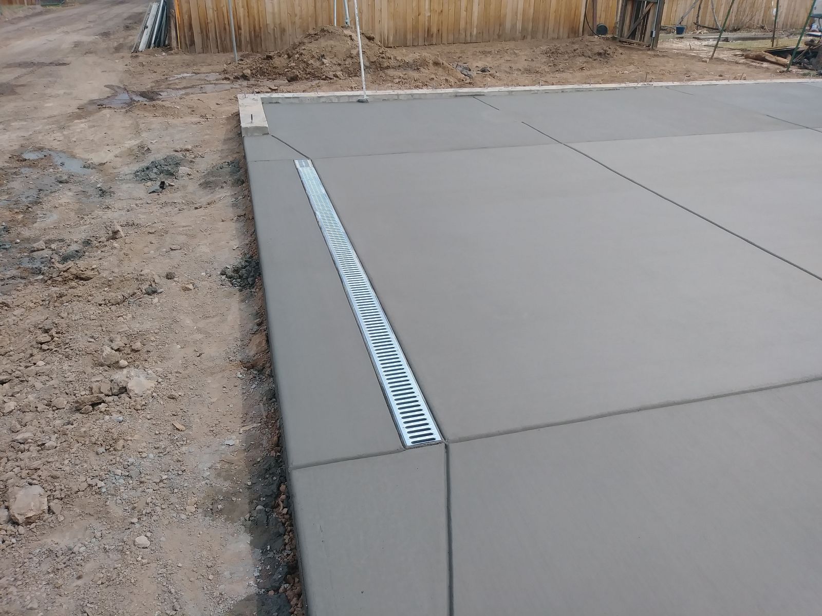 Precision Poured Concrete Slab with Integrated Trench Drain System by Happy's Concrete