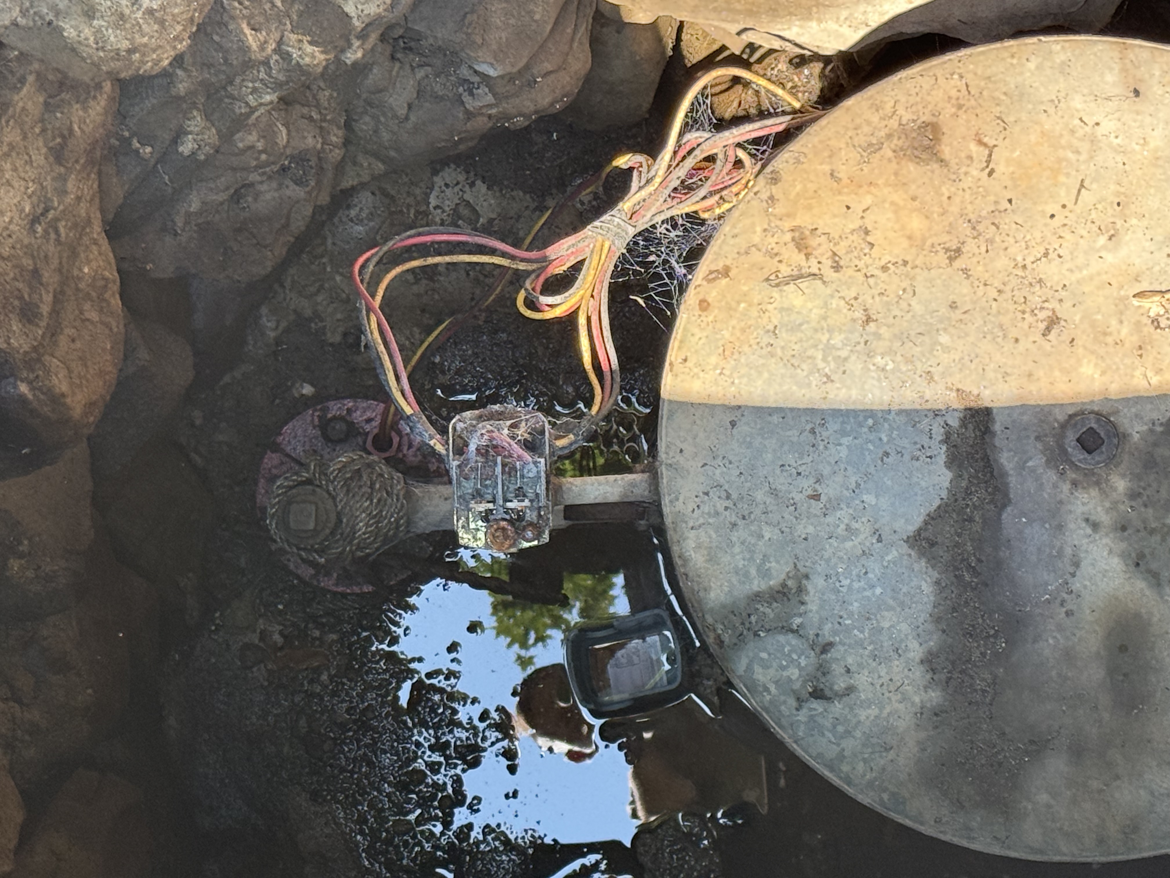 Deteriorated wiring and pitless adapter submerged in a flooded well pit — Sunrise Pump & Well Water Service