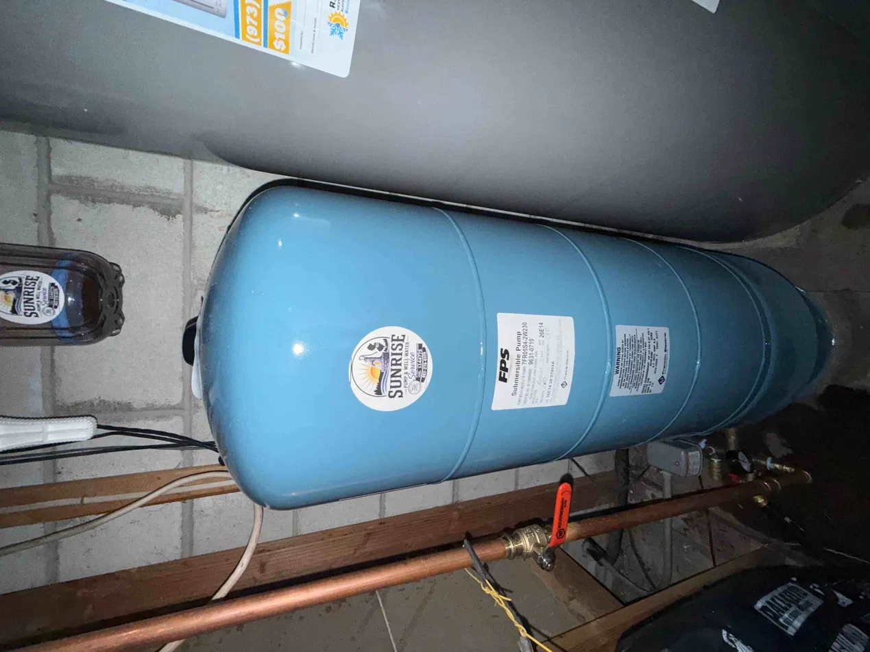 New pressure tank installed with the submersible pump specification label — Sunrise Pump & Well Water Service