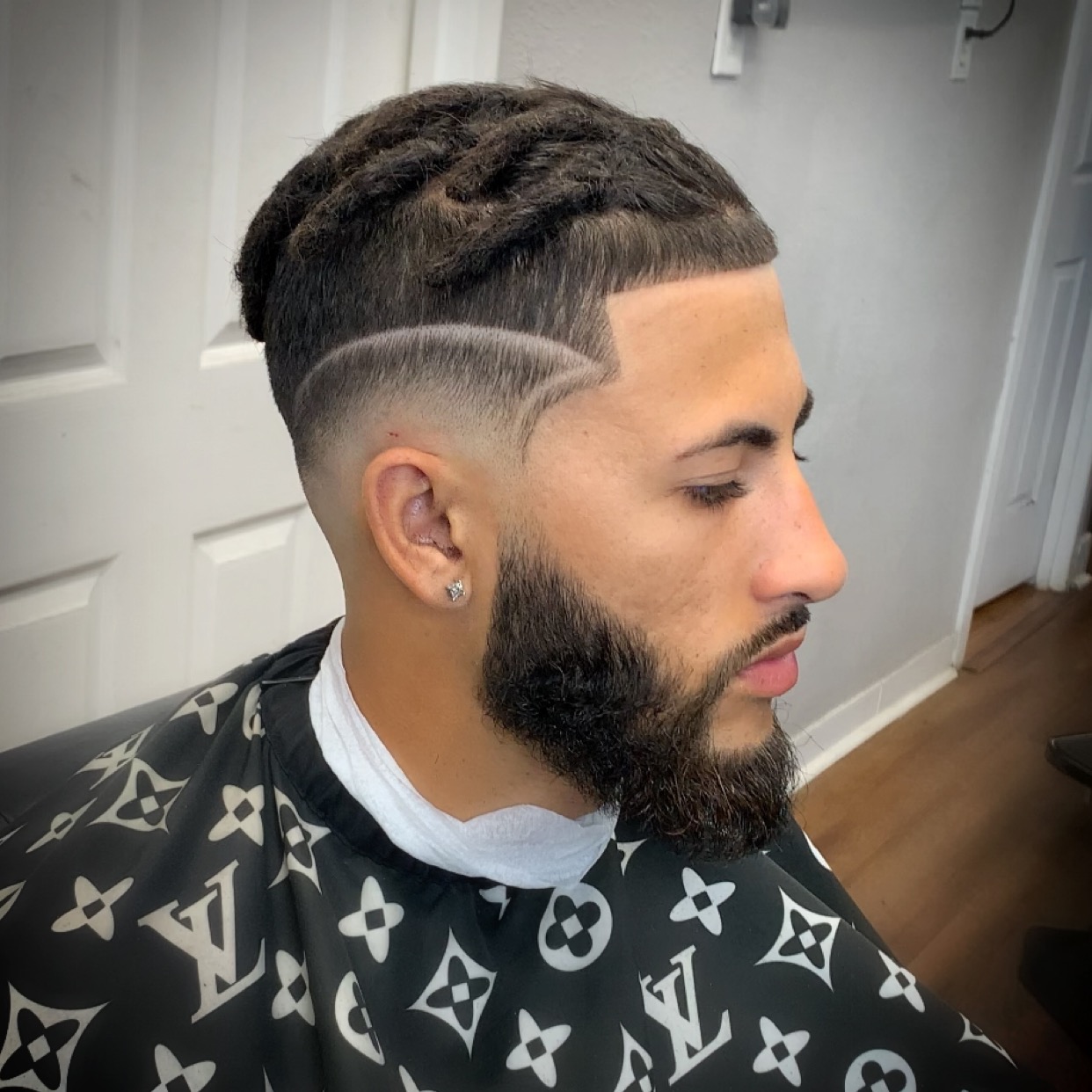 Taper fade with razor-sharp custom line design by The Grooming Gallery