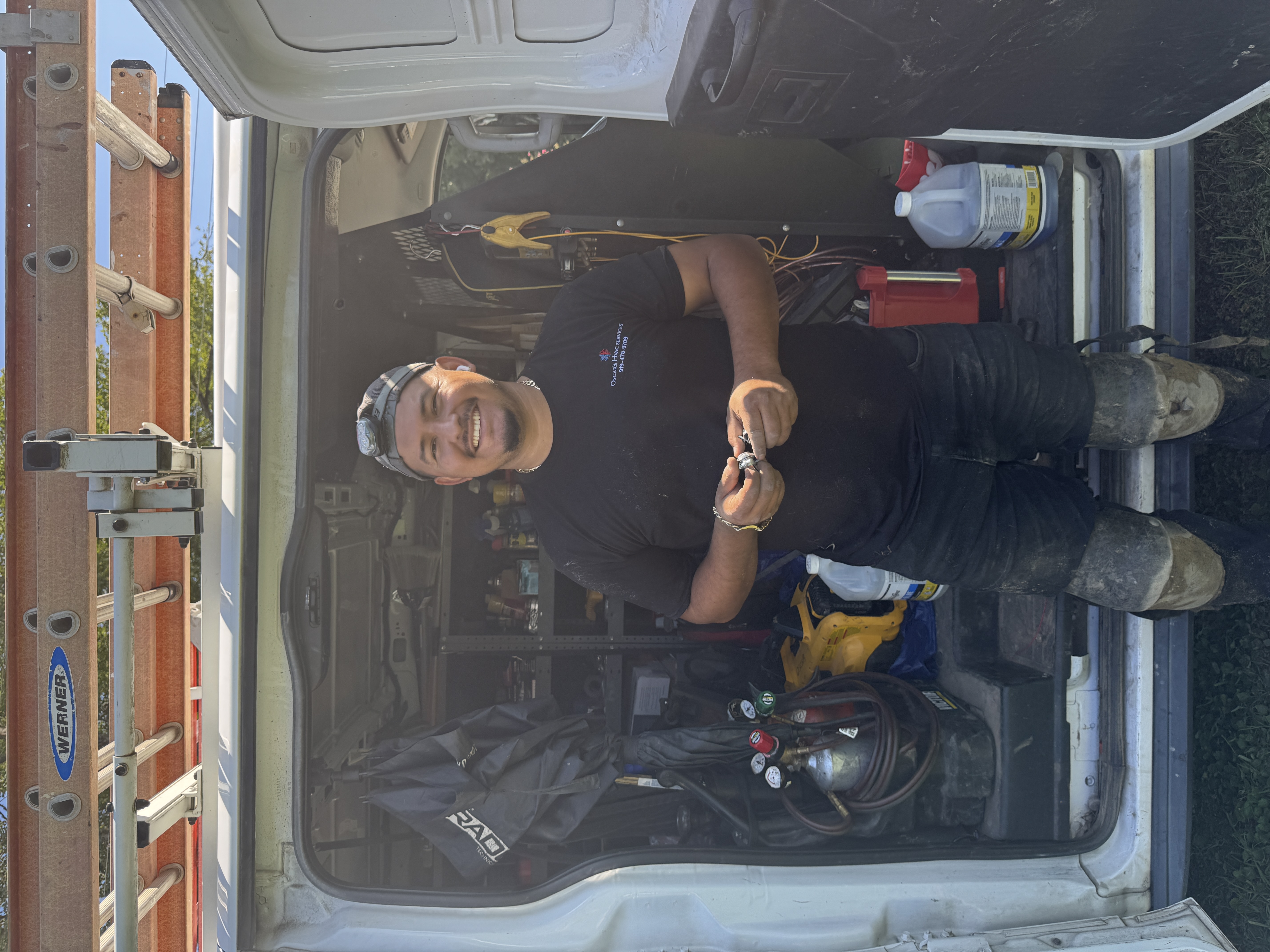 Oscar Aguirre with his work van and HVAC equipment