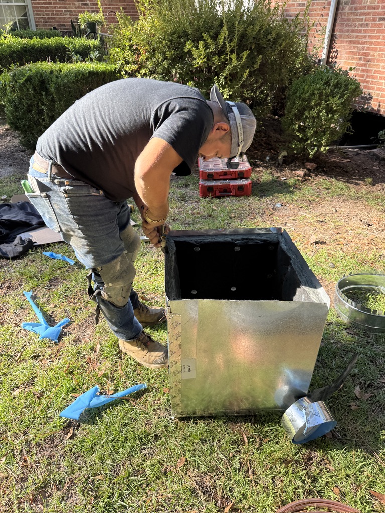 Oscar Aguirre preparing and assembling custom ductwork plenum outdoors
