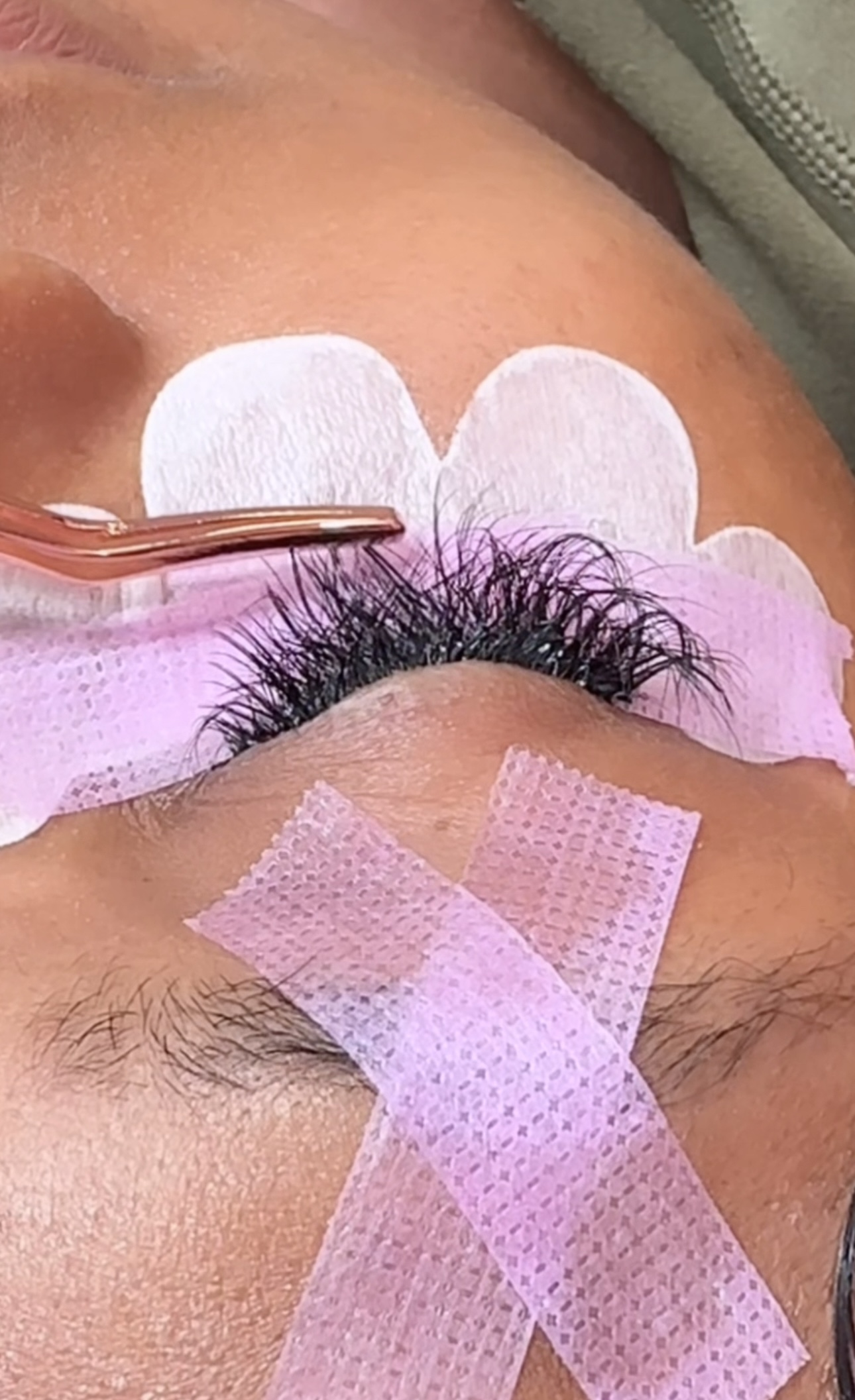 Hands-on lash cluster application technique with pink tape prep