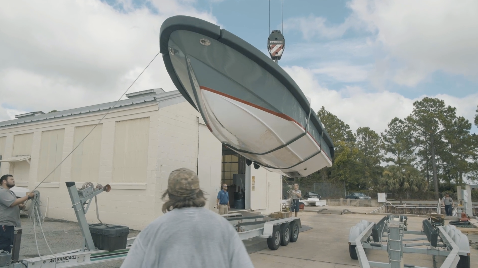 Thunderbolt Marine crane lifting boat off trailer in service staging area