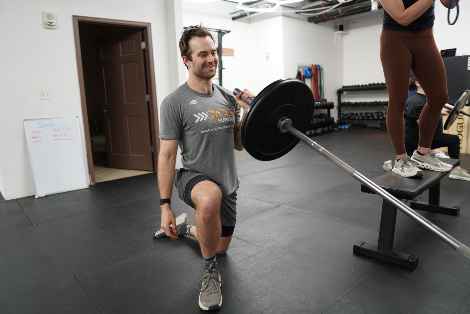 Member executing customized landmine press under coaching guidance