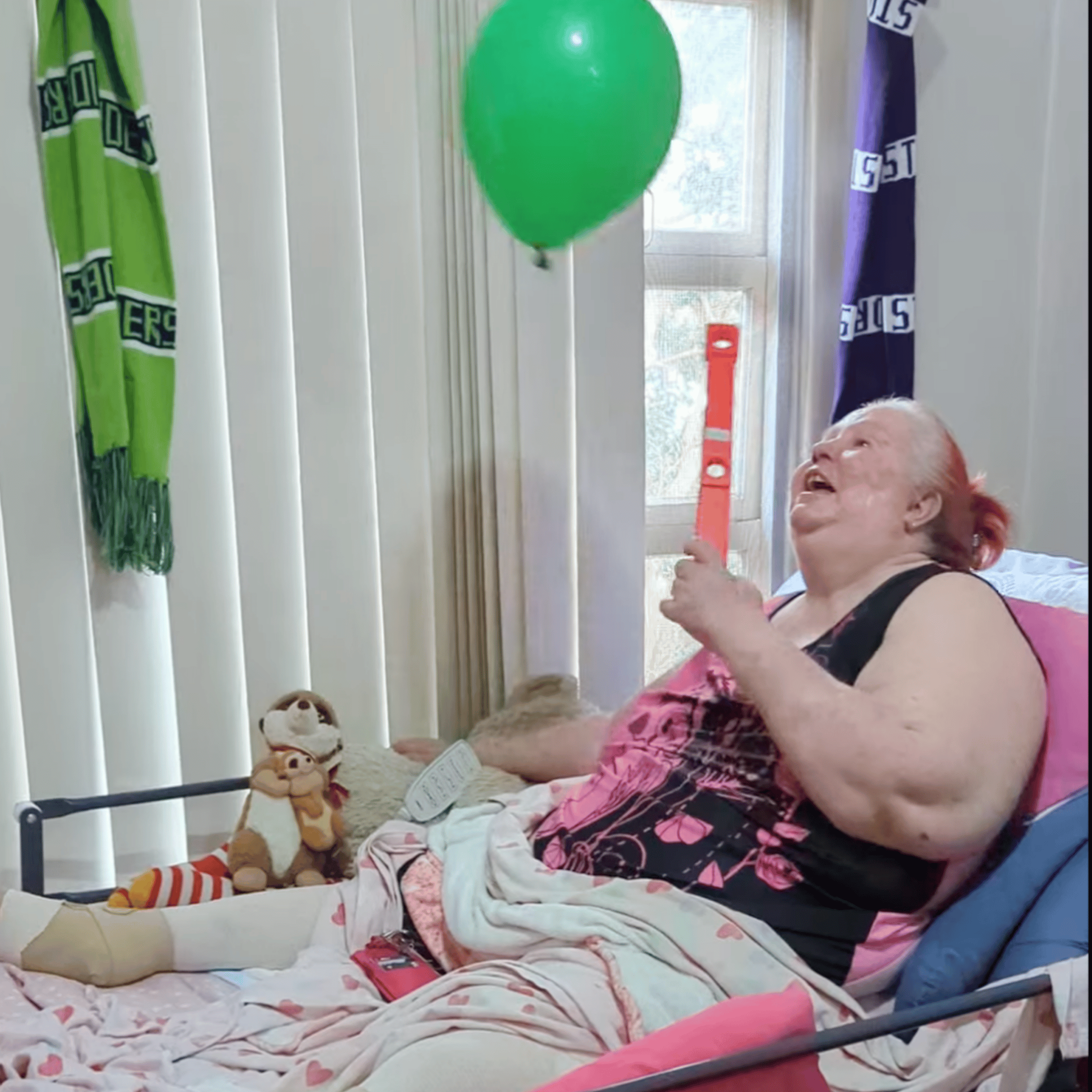 A home visit client exercising with a balloon and bat during rehabilitation